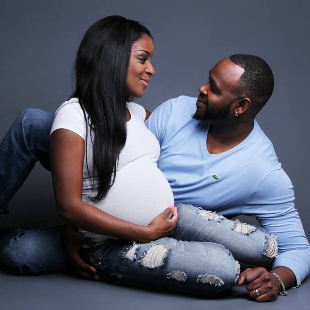 Photo of two parents cuddling and looking into each other's eyes.