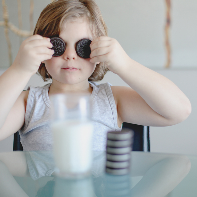 Photo of a little girl eating Oreos cookies in dining room.